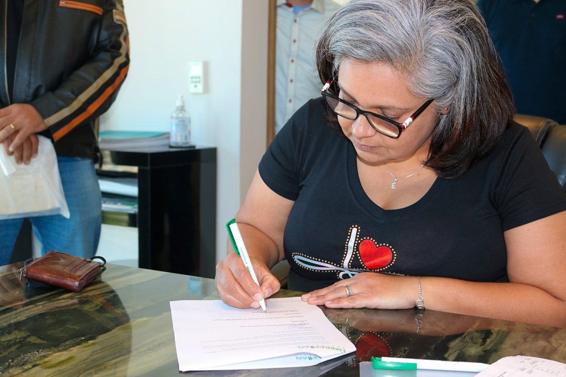 Elaine Cristina Simões assina documentos para receber o apartamento da Embraplan. Foto: Prefeitura de  Piracicaba / Divulgação
